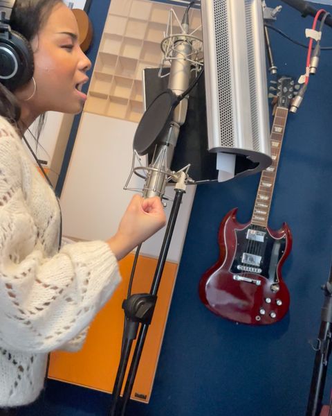 Fayth Ifil recording vocals with headphones on